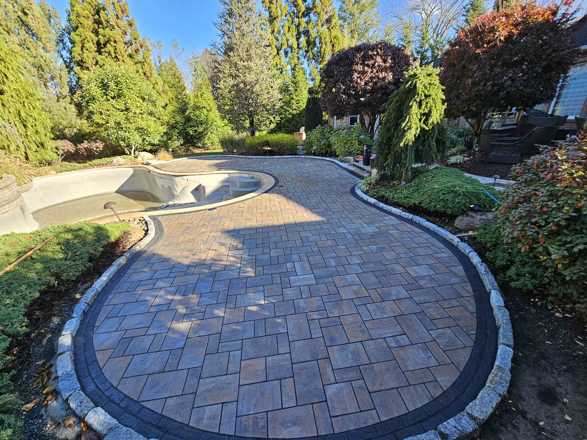 Stone patio surrounded by trees and bushes